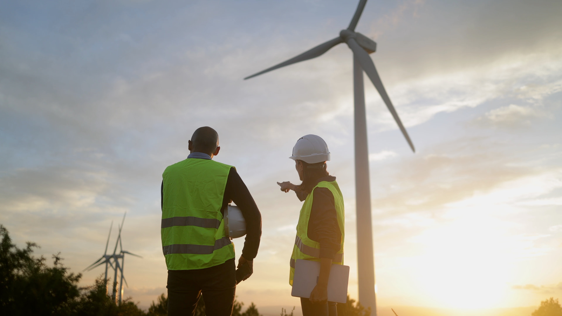 Safety professionals reviewing a utility-scale renewable energy site at sunset